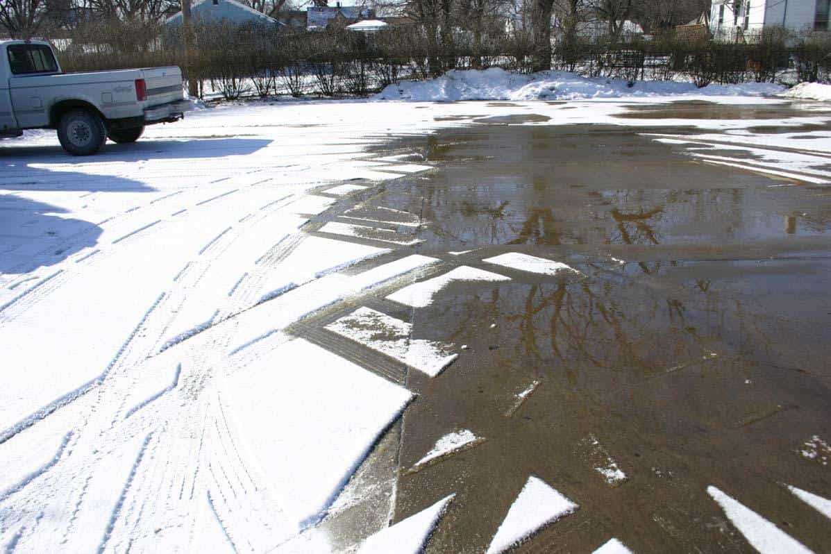 a parking lot with one half treated with Fusion and the other half untreated. The treated side is clear of ice and snow while the other side looks untouched